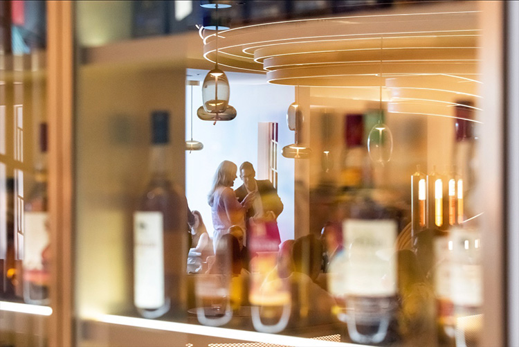 Edinburgh Camber of Commerce event at Johnnie Walker Edinburgh, Business meeting in Explorers Bothy, reflection whisky cabinet of people talking